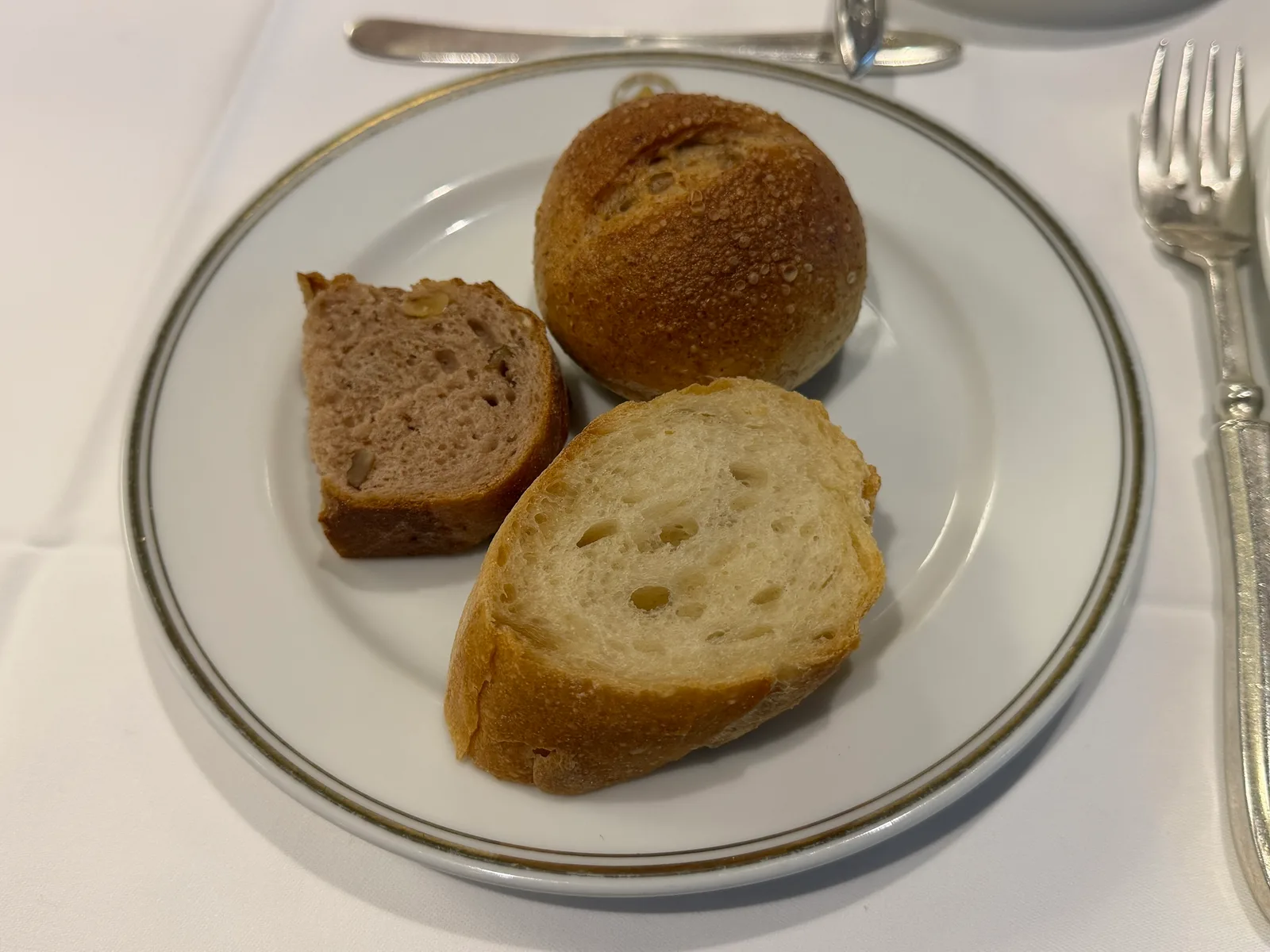 白い皿にパンが3種類。まるいパンと、スライス2枚