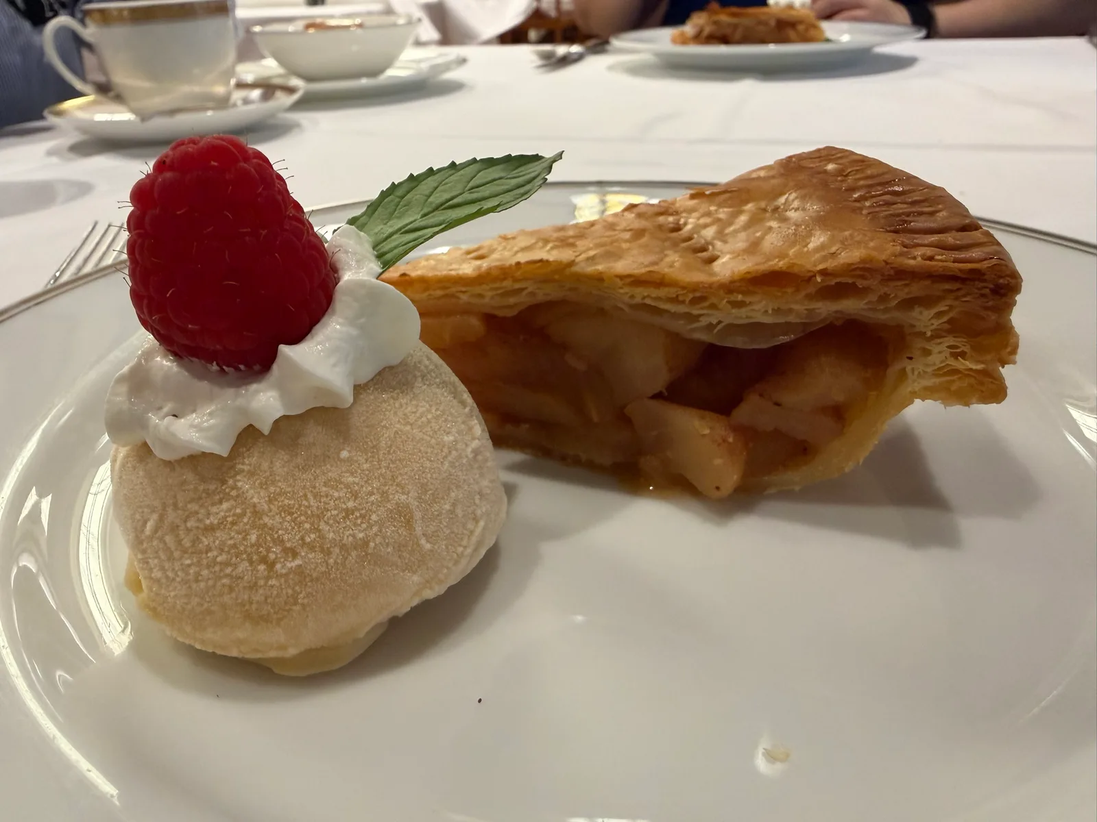 アップルパイ アラモード。アイスに木いちごとミント、パイの断面にりんご
