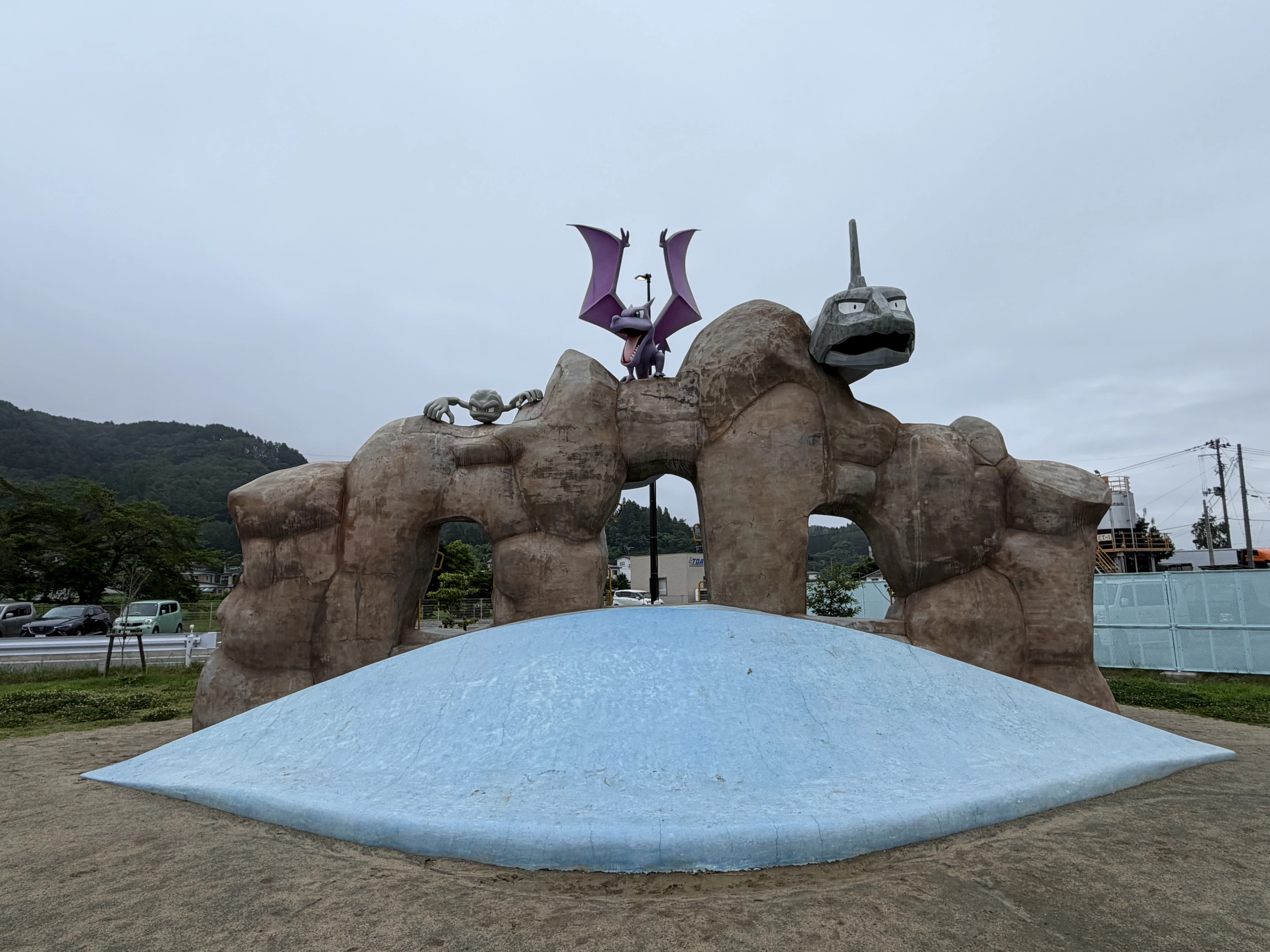 岩山型のポケモン遊具の正面全景。頂上にプテラ