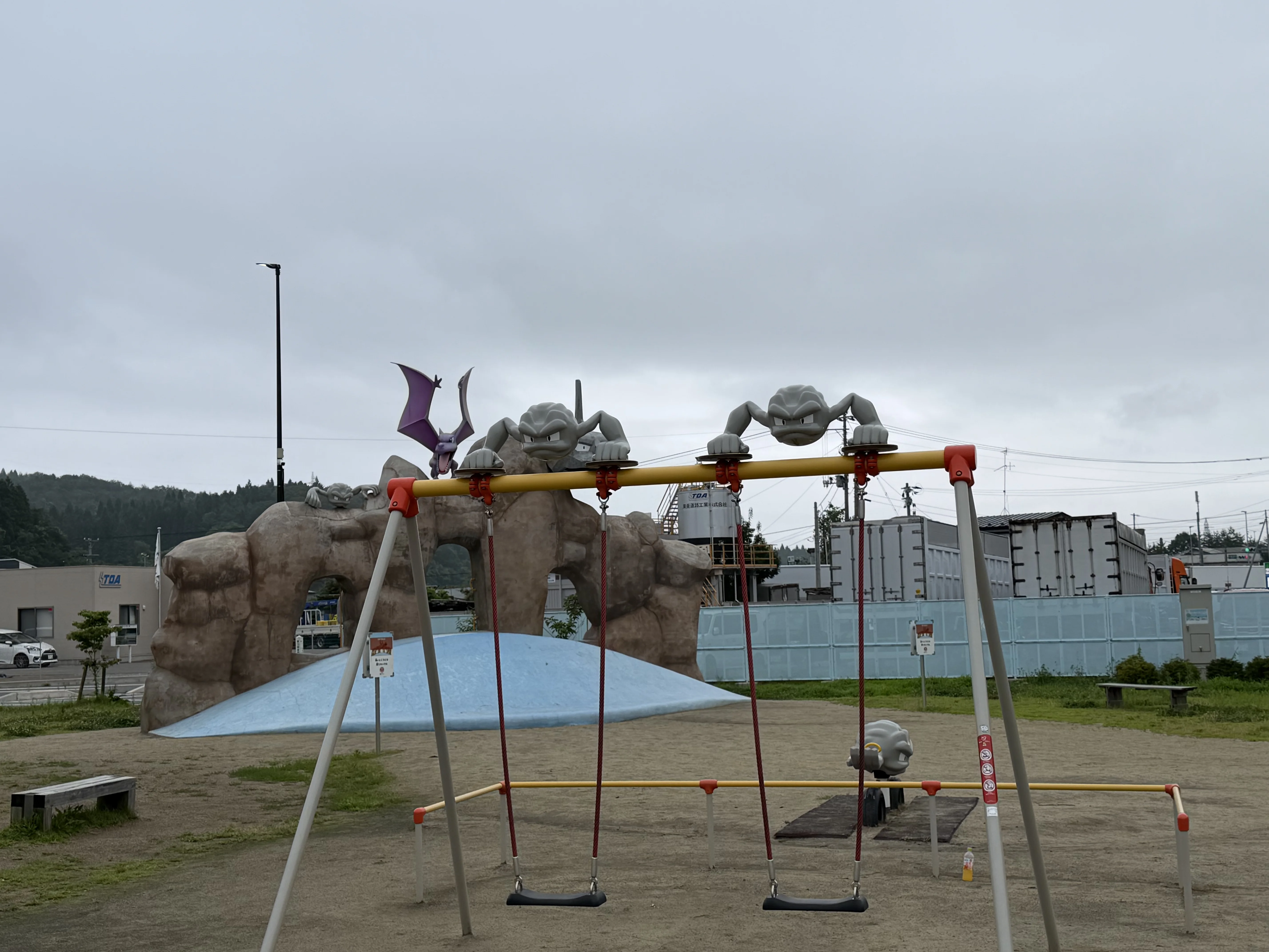 ブランコと岩山型遊具のある遊具エリア