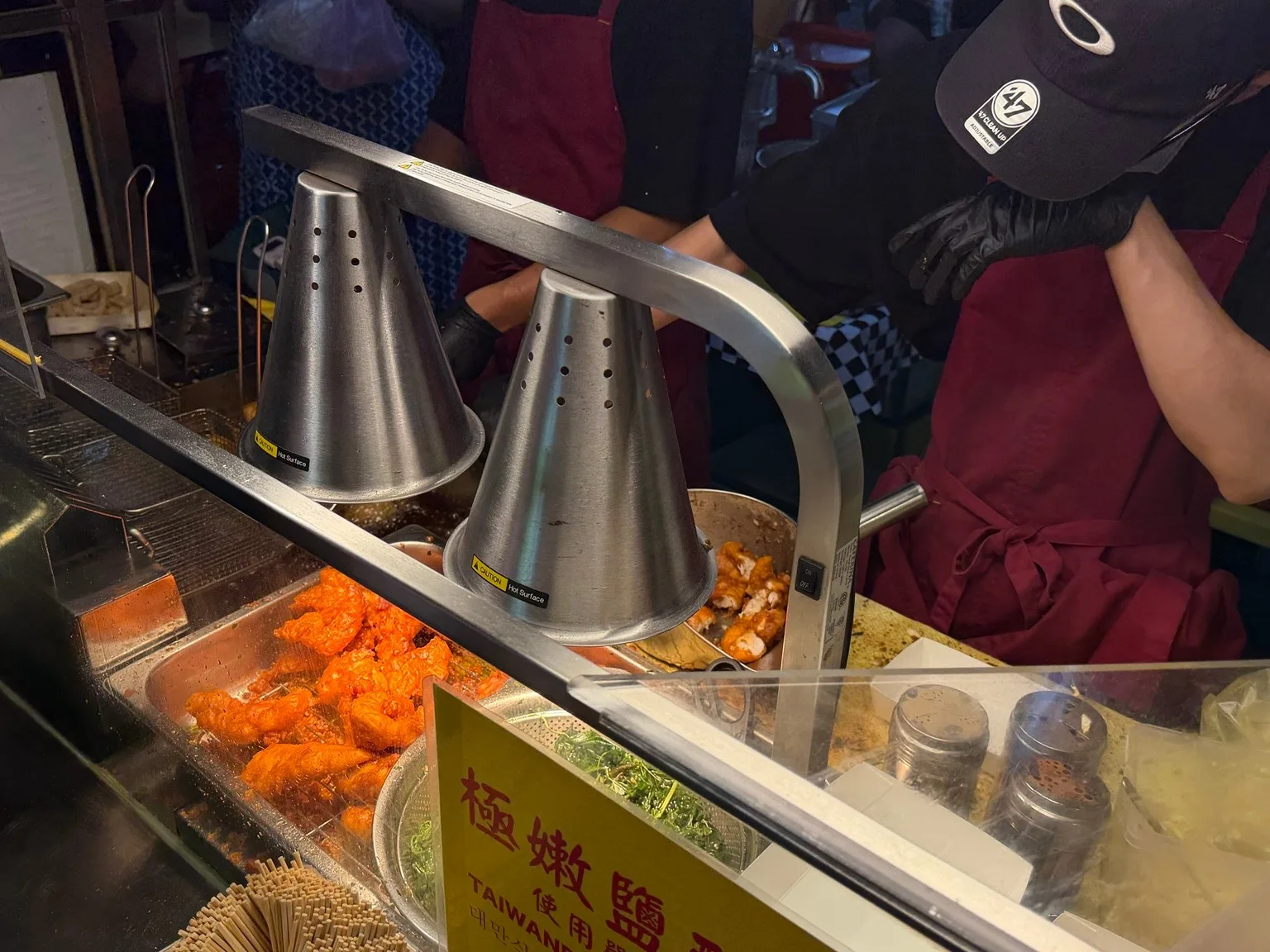 保温ランプの下、オレンジ色の鹽酥雞が並ぶ屋台