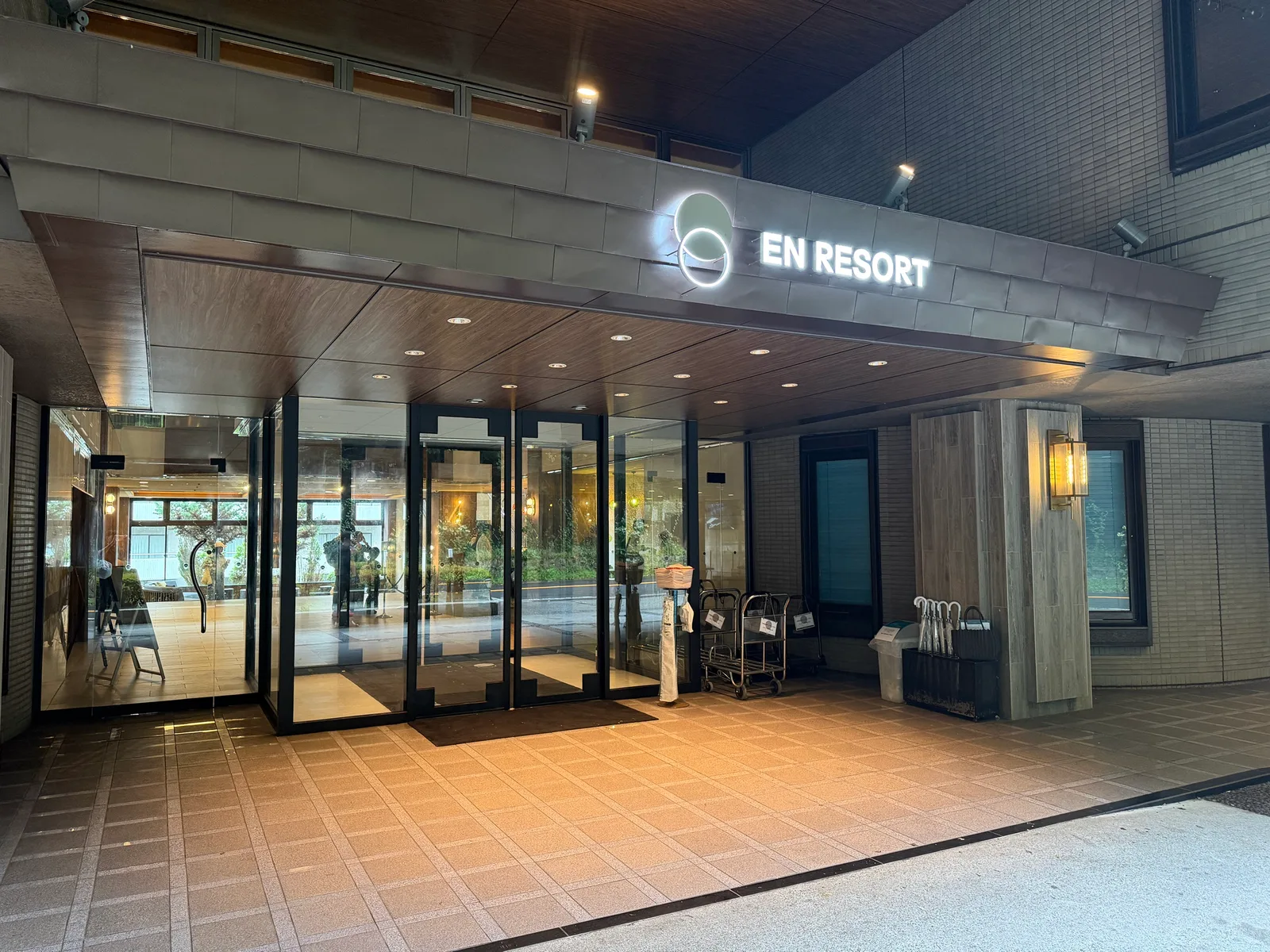 雨の日の「EN RESORT」エントランス。白いロゴが光る