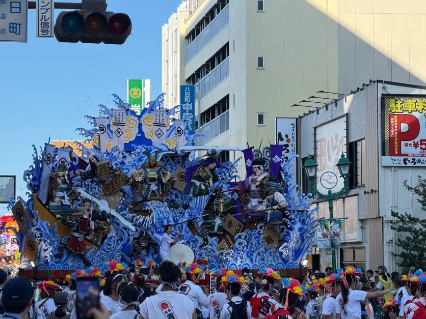 青い波を背景にした山車