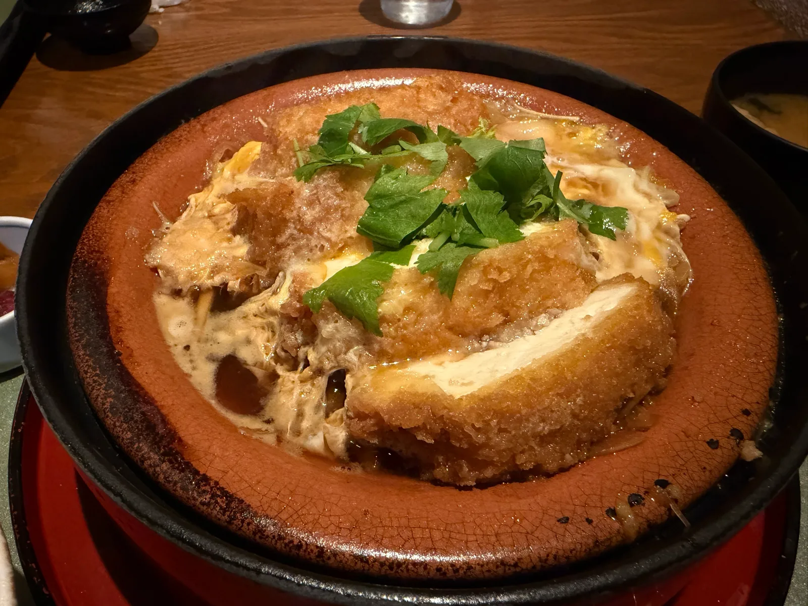 最初から切り分けられた豆腐かつ煮。白い豆腐の中心に豚ひき肉の餡が見える